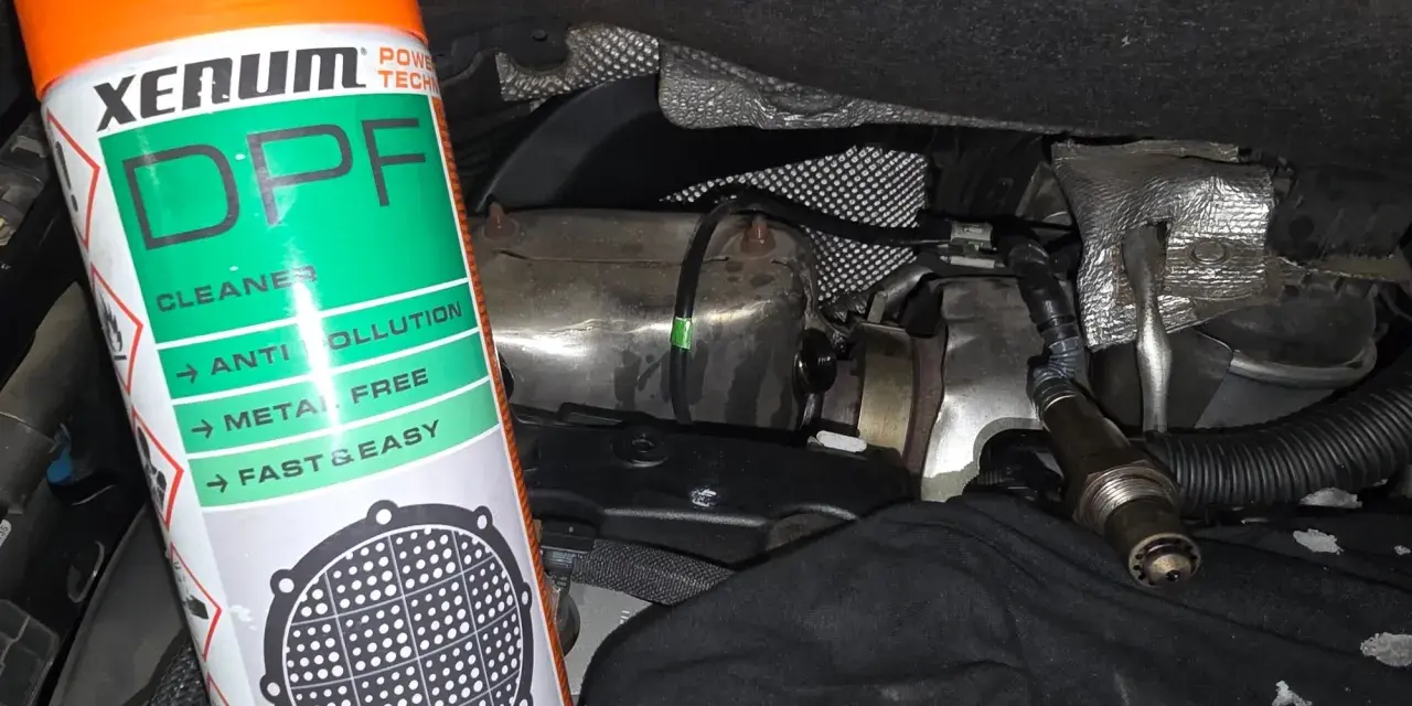Bouteille de nettoyant FAP Xenum à côté d'un capteur et de pièces de moteur.